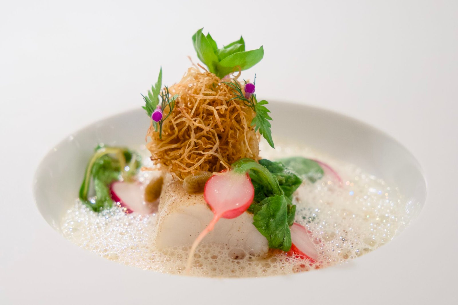 Söl’ring Hof Sylt: elegantes Gourmetgericht mit Schaum und Nest.
