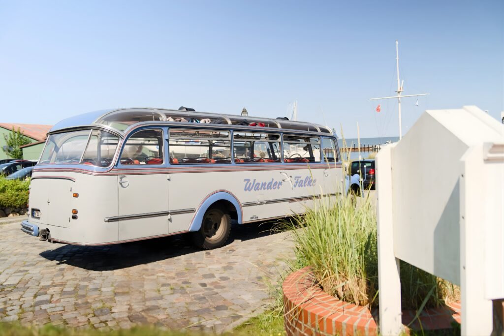 Blau-weißer Wander-Falke-Bus auf Kopfsteinpflaster geparkt.