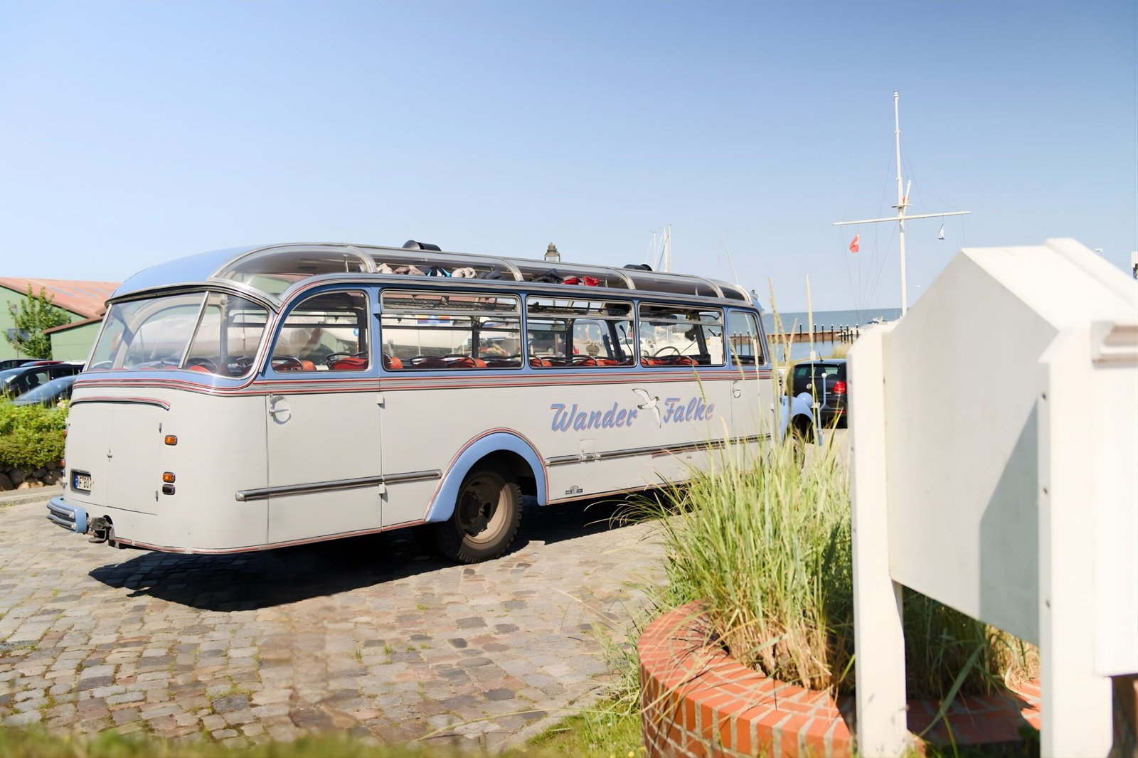 Blau-weißer Wander-Falke-Bus auf Kopfsteinpflaster geparkt.