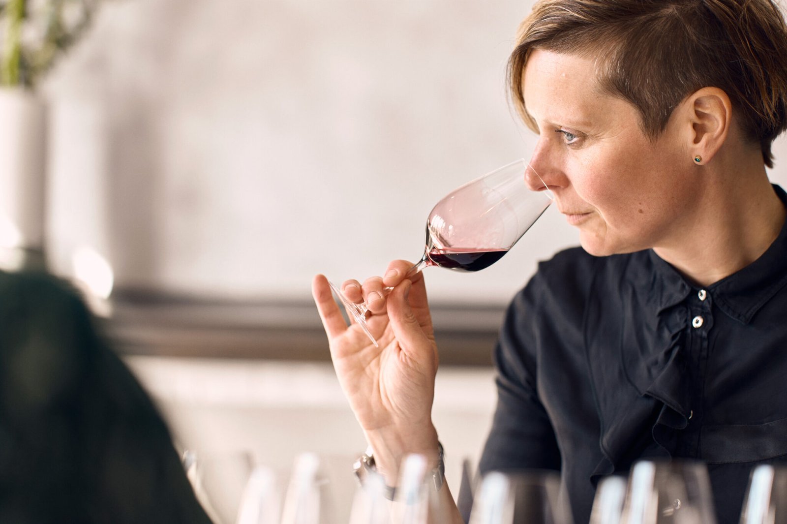 Eine Person, die im Söl’ring Hof, einem Urlaubsziel auf Sylt, Wein genießt.