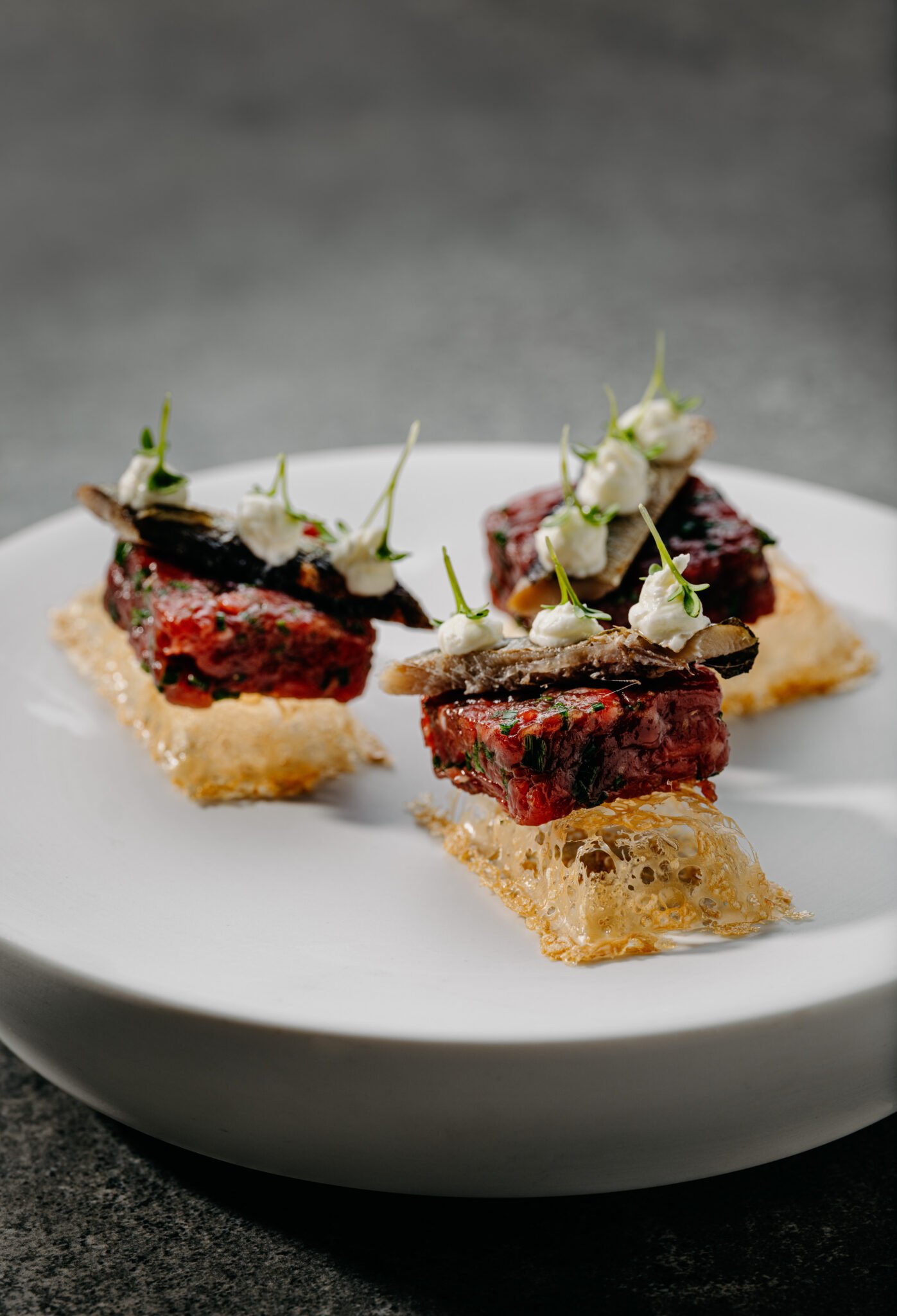 Gourmet-Vorspeisen mit Fleischwürfeln, Pilzen, Sahne und Mikrogrün.