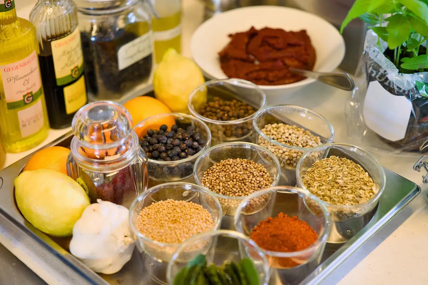 Gewürze, Samen, Zitronen, Knoblauch und Ölgläser auf der Küchenarbeitsplatte.